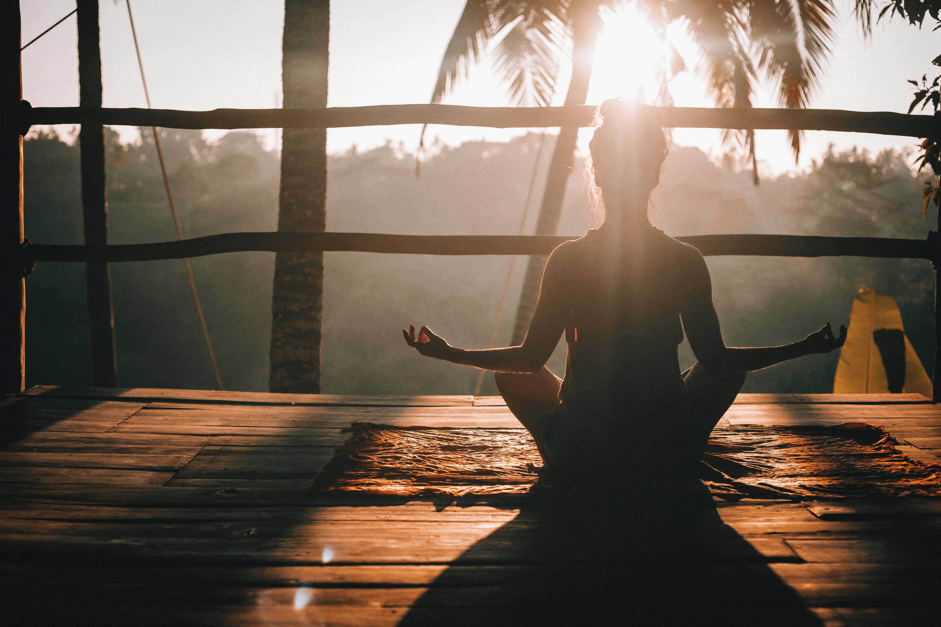 Meditating on a wooden deck in morning sun