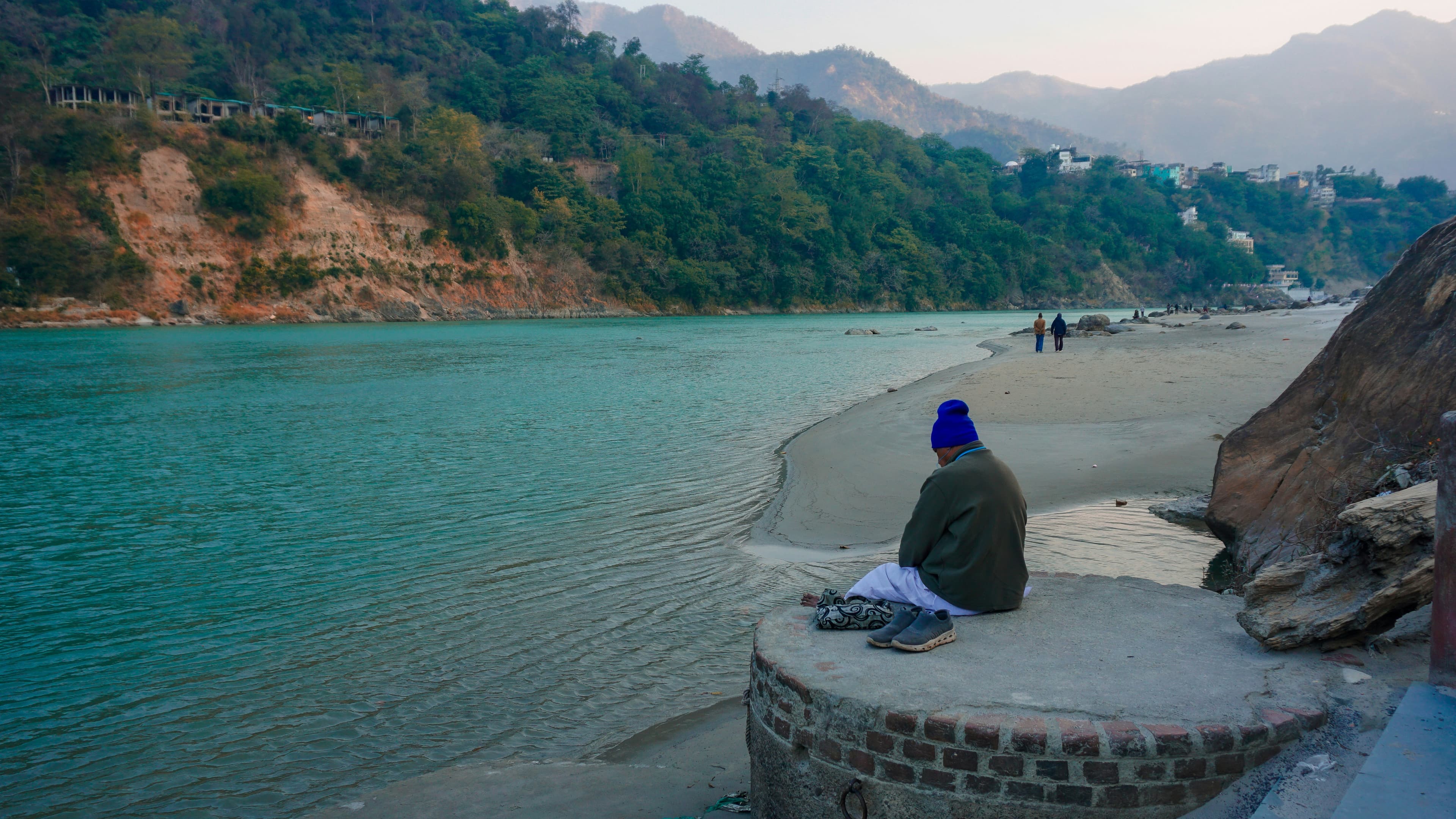 Someone sitting quietly by the turquoise Ganga