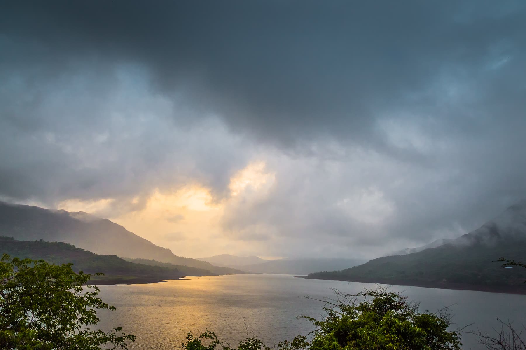 Sunrise breaking through clouds over the Mulshi backwaters