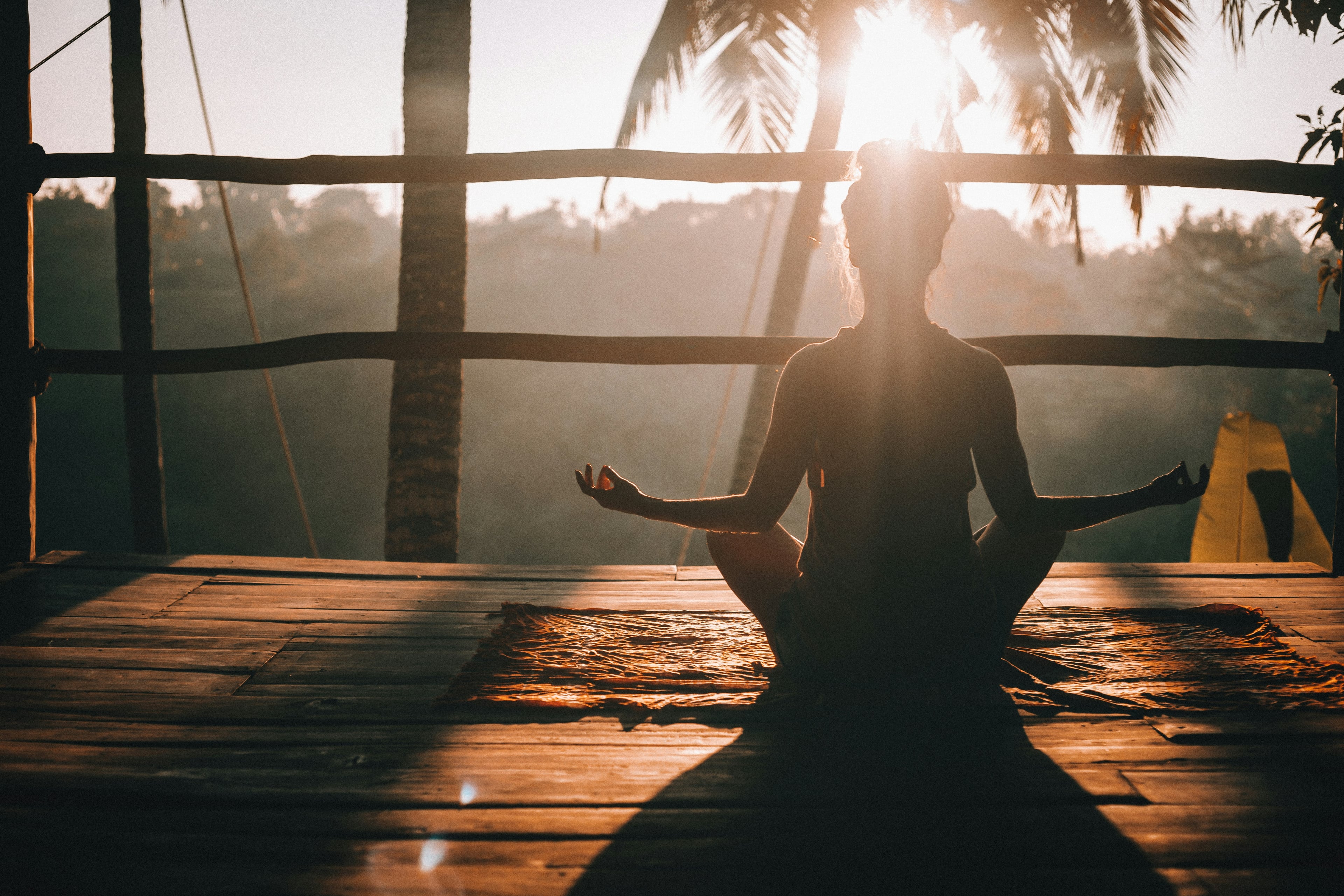 Meditating on a wooden deck in morning sun