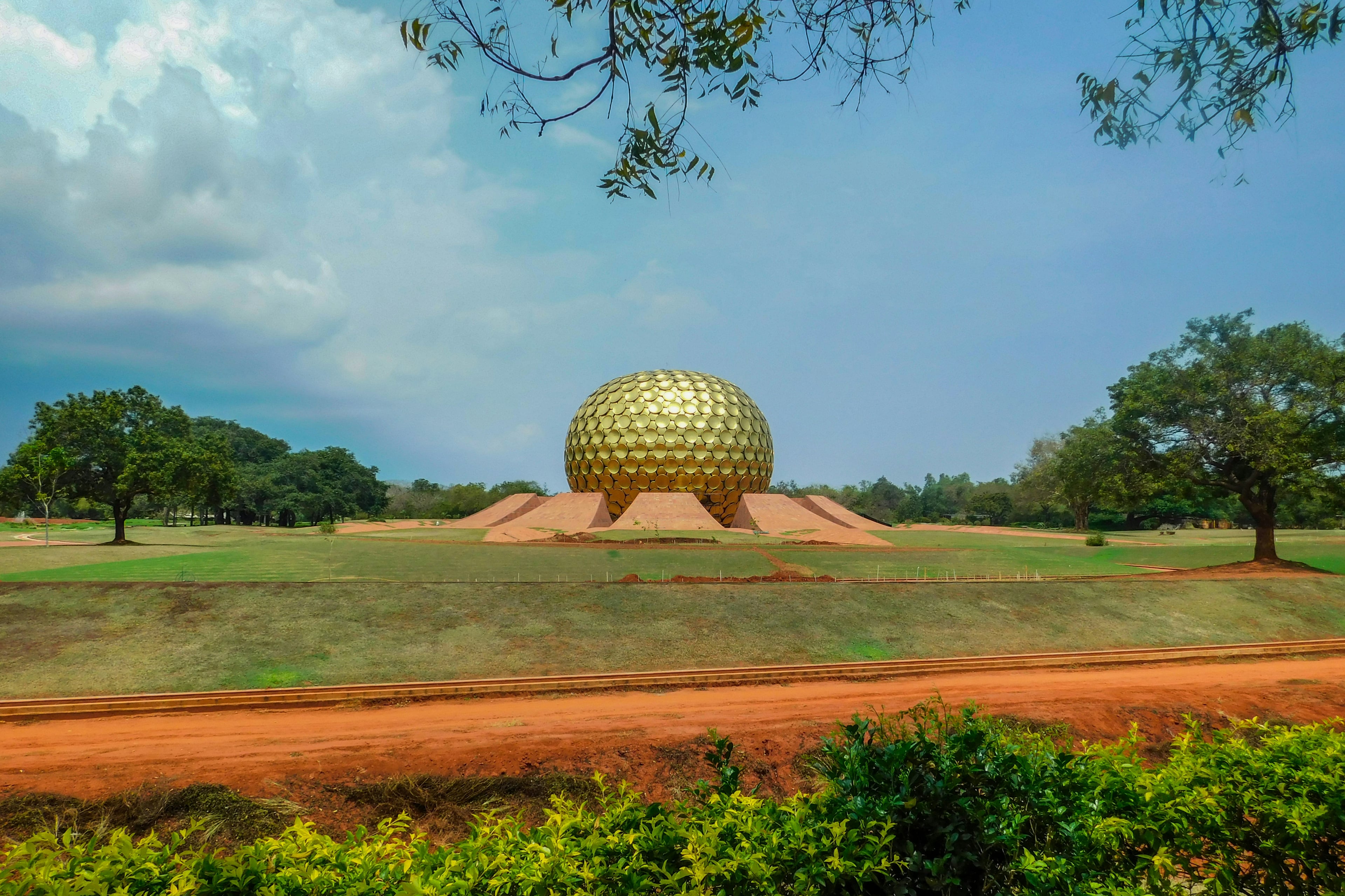 Matrimandir seen across open grounds, Auroville