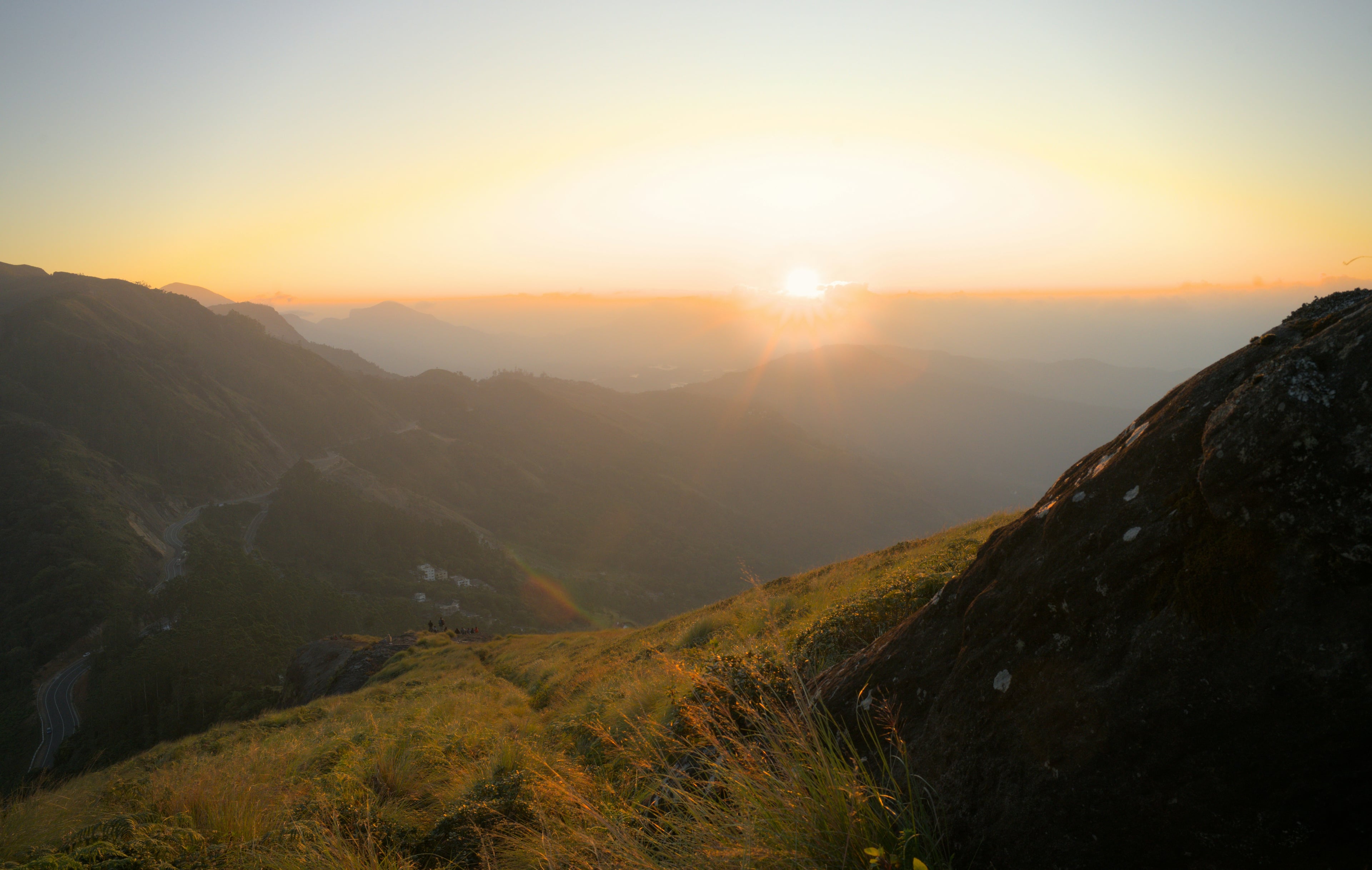Sun setting over a forested mountain range